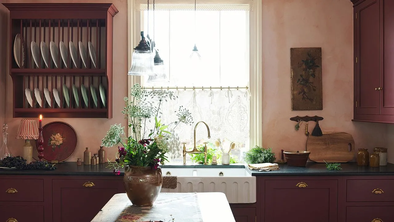 Cocina deVOL de estilo tradicional inglés con gabinetes rojos, paredes rosadas e isla de madera con jarrón y flores' loading='lazy' title=