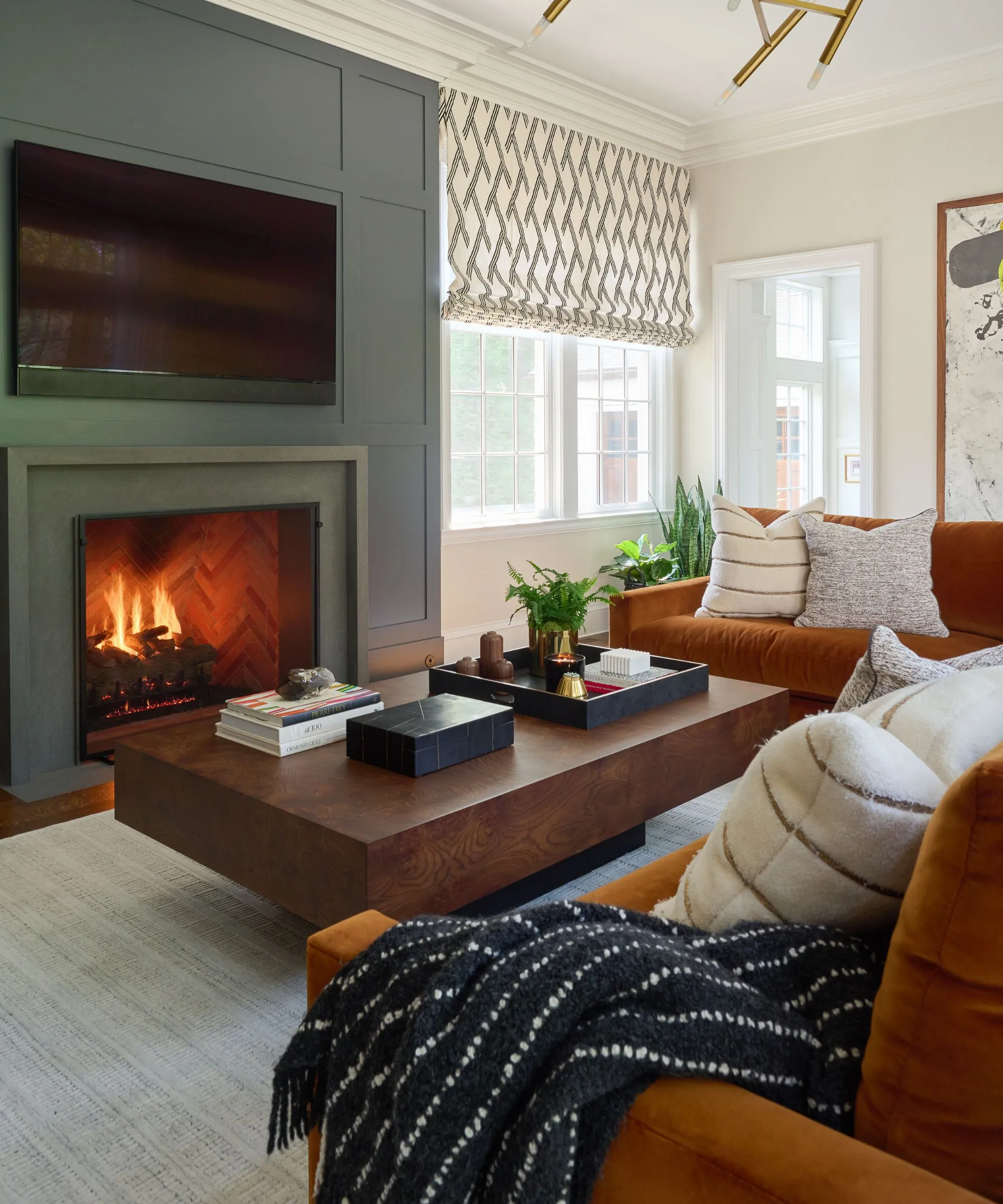 sala de estar moderna verde y naranja acogedora con una chimenea con paneles y pintado una mesa de café de fuego de fuego litigerada y un sofá de terciopelo de color naranja grande y verde' loading='lazy' title=
