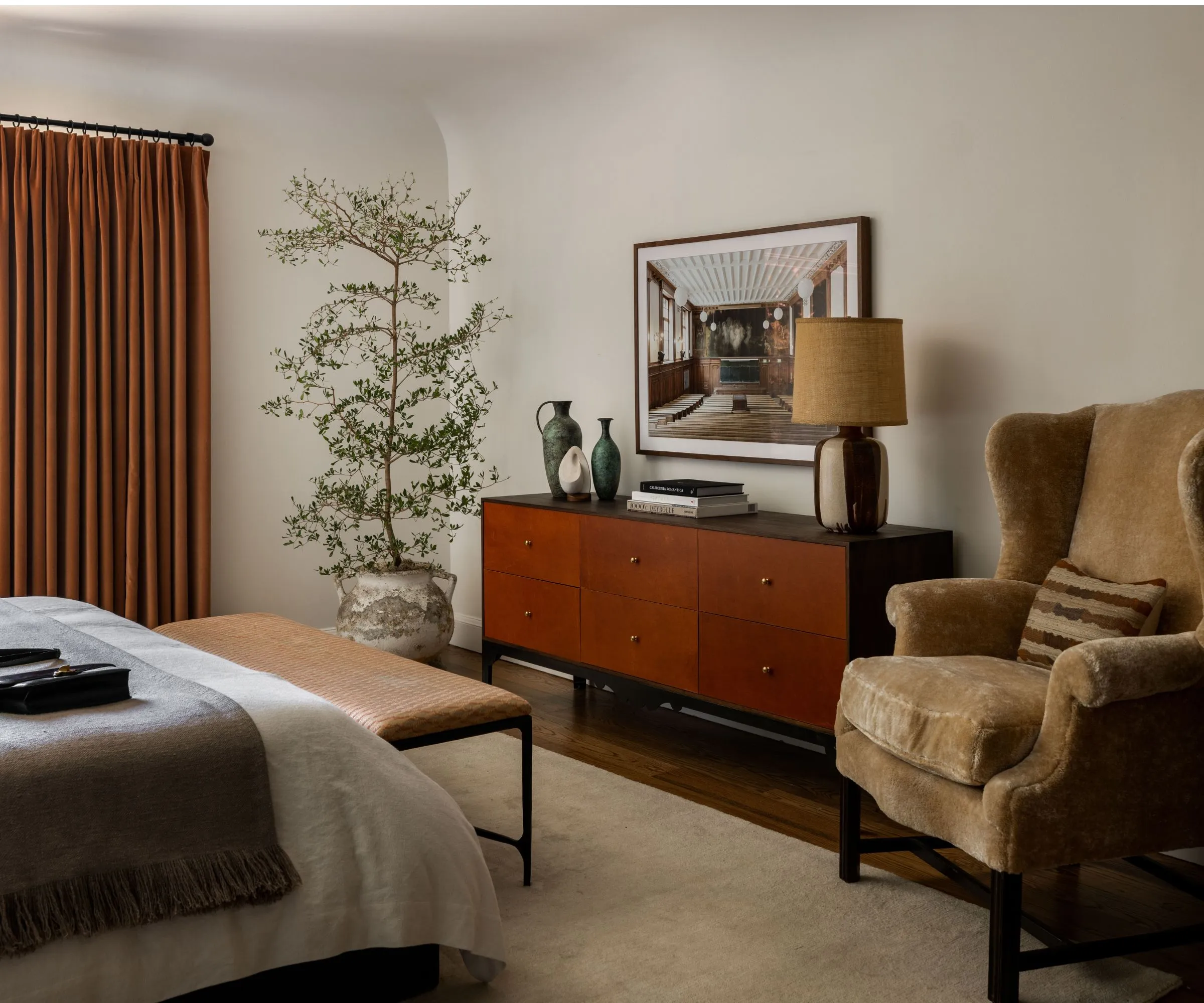 NEUTRO COZO DORMITORIO MODERNO MODERNO CON PISO DE MADERA Una alfombra de pila grande y grande cortinas de naranja quemada una cama de estilo neutro con una planta de parque de madera negra y de teca Woode y piel de oveja' loading='lazy' title=