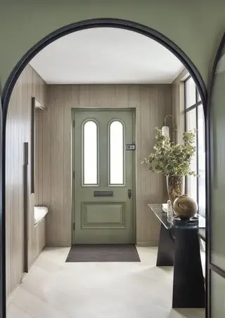 Corridoio rivestito con porta d'ingresso verde