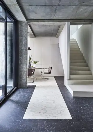 ingresso moderno con lussuoso pavimento in vinile effetto pietra, tavolo da pranzo sullo sfondo, scala in pietra