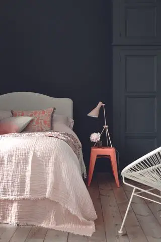 camera da letto con parete nera, armadio antracite, letto grigio, accenti corallo