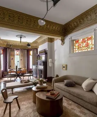 Salón de planta abierta con sofá marrón y detalles en violeta.