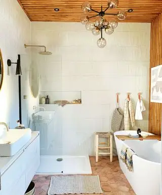 Baño con azulejos color crema y paneles de pared.