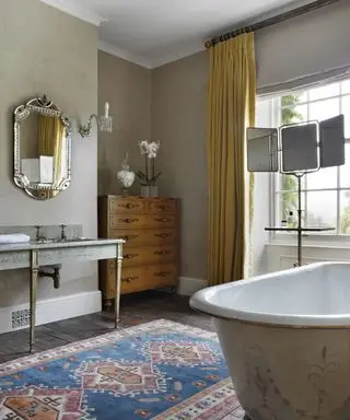 Diseño de baño inteligente con largas cortinas amarillas y alfombra estampada.