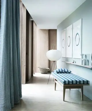 gang med elegant daybed og blå og hvid stribet gardin