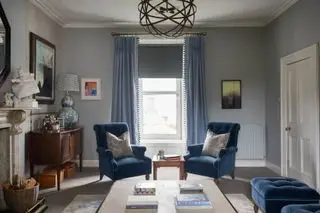 sala de estar azul com poltronas azuis, cortinas azuis e persiana azul