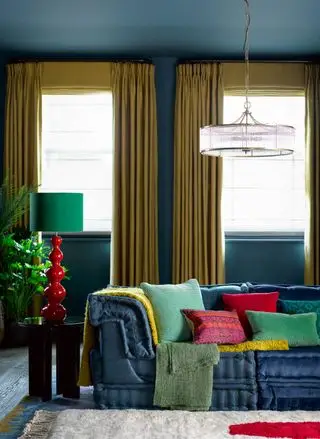 sala de estar com cores fortes e sofá azul e persianas e cortinas combinando na cor açafrão