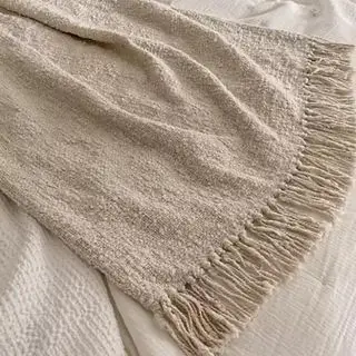 Eine Bouclé-Überwurfdecke über einem Bett drapiert