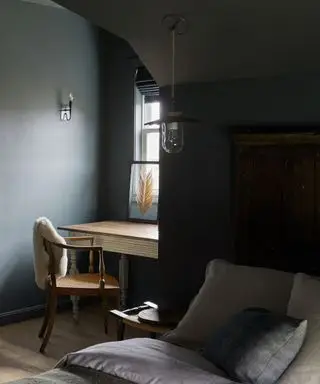 Ein blaues Zimmer mit einem kleinen Nischenschreibtisch