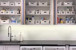Vaskerom med skap og benkeplate og hyller over