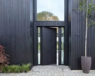 Puerta de entrada negra y revestimiento negro, granero convertido