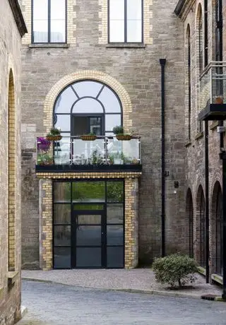 Casa con paneles blancos y puerta de entrada rústica.