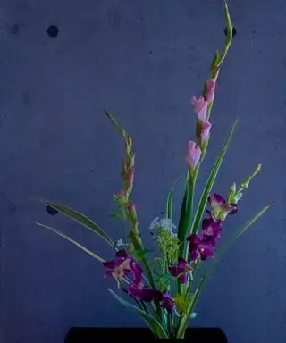 Un arreglo floral de Ikeaba con flores moradas.