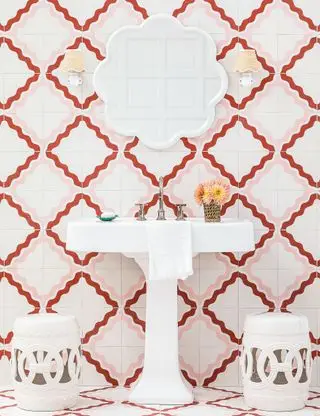 Banheiro rosa com parede de azulejos e acessórios brancos