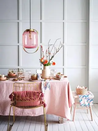 Mesa de jantar rosa e acessórios com painéis de parede cinza claro