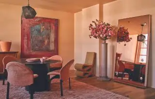 Espaço contemporâneo com paredes de gesso rosa e cadeiras de veludo