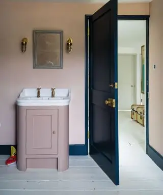Móvel de toucador rosa e paredes contrastantes com madeira azul marinho