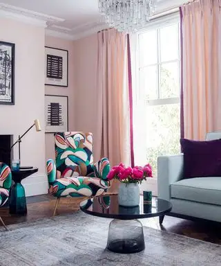 Sala de estar rosa com cortinas combinando e poltronas com estampa abstrata