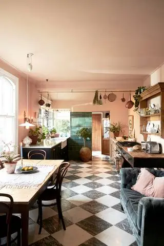 Armários de cozinha pretos com paredes e teto rosa