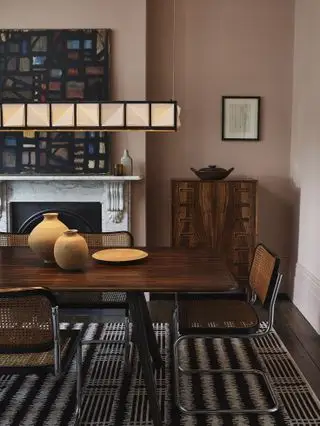 Salle à manger avec table et chaises, et suspension au dessus, commode et cheminée