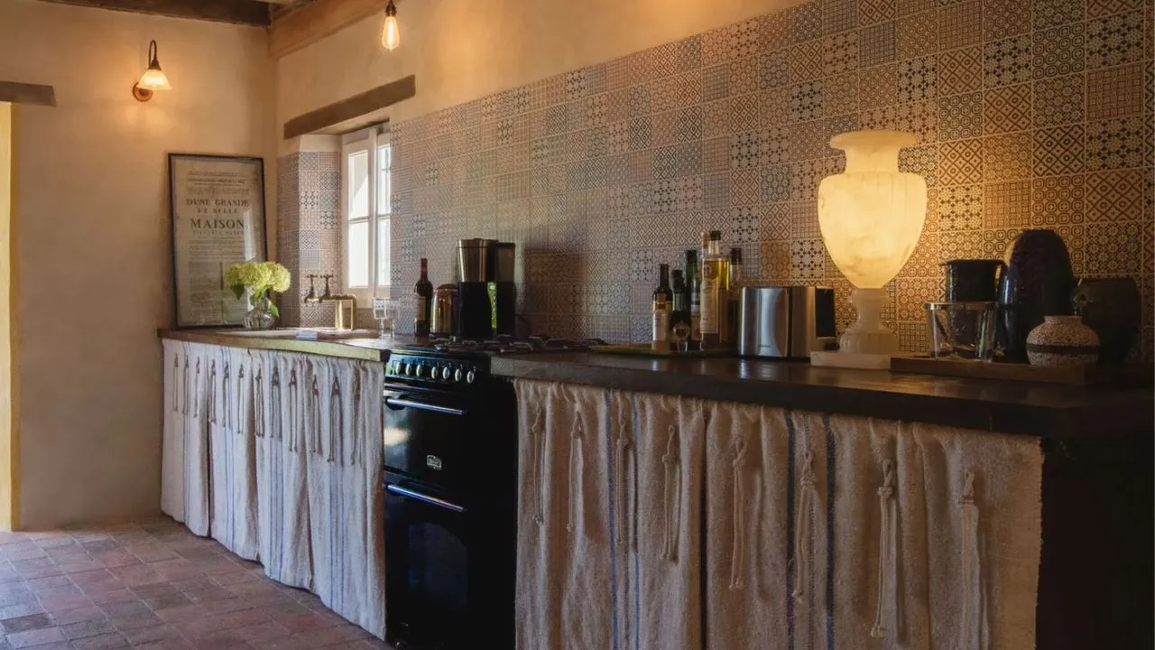 Et fransk landkjøkken med skapgardiner og lagdelt belysning' loading='lazy' title=