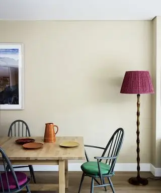 Esszimmer mit Esstisch und Esszimmersesseln aus Holz, Stehlampe mit rosa Lampenschirm