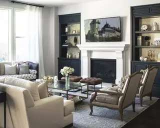 Salon noir, blanc et gris, cheminée, étagères d'alcôve noires, sièges, tapis gris