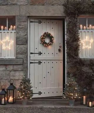 Haustür und Fenster mit Weihnachtsbeleuchtung im Innen- und Außenbereich dekoriert