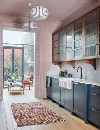 Cuisine rose avec armoires bleues et marbre