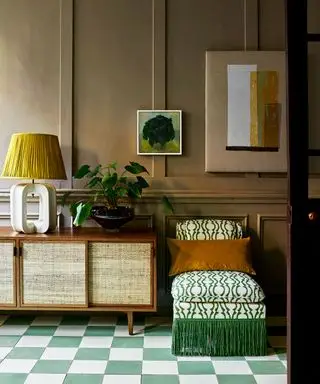 hall avec carrelage en damier vert, buffet et chaise tapissée verte