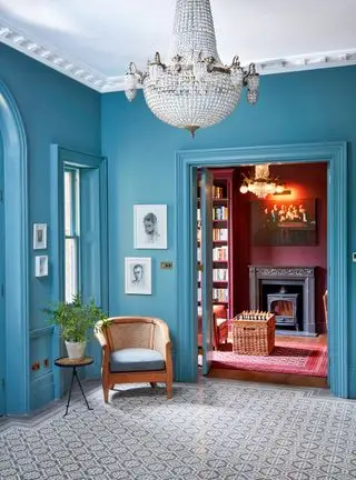 Hall peint en bleu avec sol à motifs et lustre