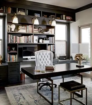 Escritório doméstico em preto e branco com prateleiras pretas embutidas e uma mesa contemporânea