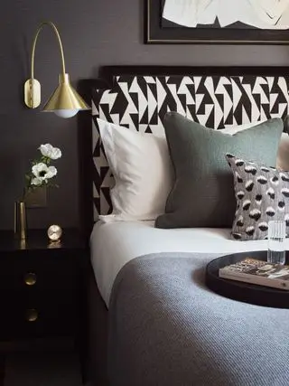 Quarto cinza escuro com aplique dourado e cabeceira geométrica