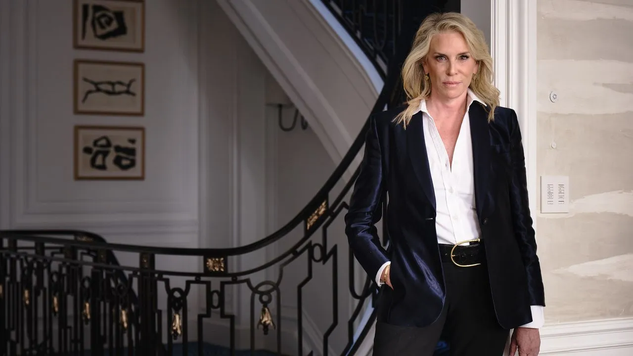 Victoria Hagan em um terno escuro parada perto de uma escada' loading='lazy' title=