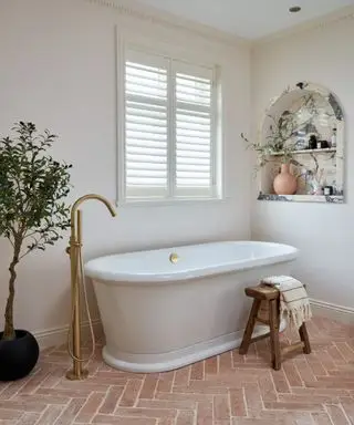 modernes Badezimmer mit Terrakottaböden und Fensterläden über einer freistehenden Badewanne