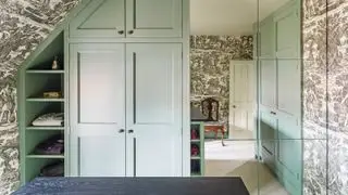Šatna s černou tapetou a zelenými skříněmi