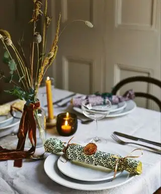 Weihnachtstisch mit Kerzen und Crackern geschmückt