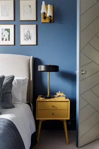 dormitorio azul con mesita de noche amarilla