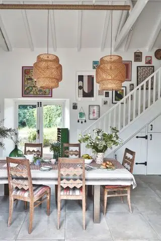Pared de galería encima de la escalera en la cocina con mesa de madera.