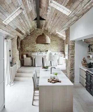 Vista interna da cozinha e área de jantar em plano aberto.