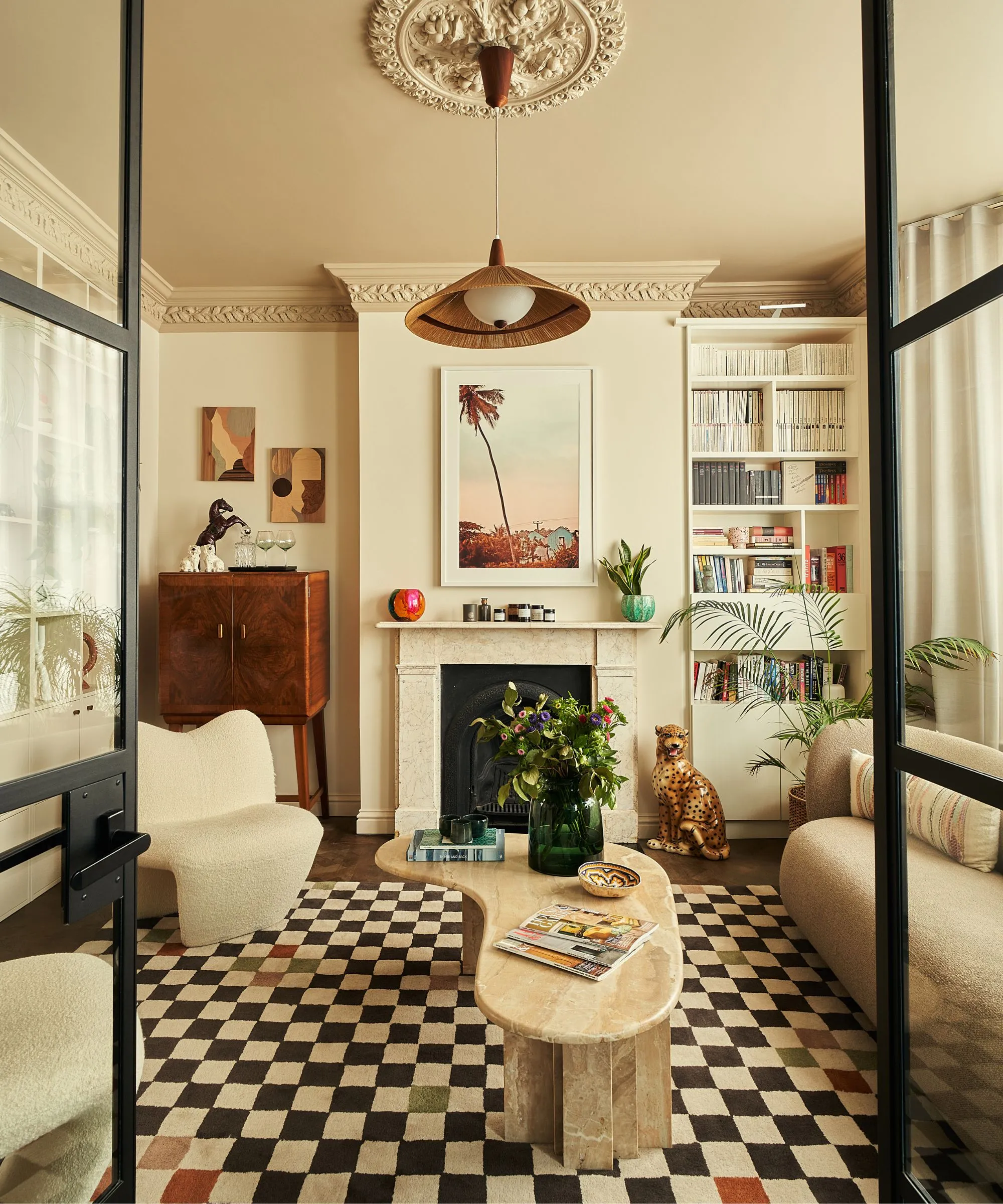 neutrálna obývacia izba s maľovaným teplým žltým stropom a obložením, vstavanou policou s vintage nápojmi a mramorovým krbom' loading='lazy' title=