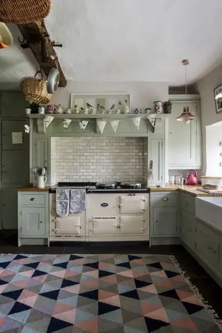 Despensa llena de latas antiguas y parcialmente cubierta por una cortina floral vintage.