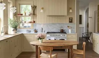 Cocina vintage con paredes color crema, salpicadero de mármol e iluminación vintage
