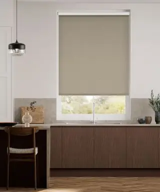Cozinha moderna marrom com armários de madeira escura, ilha de cozinha com assentos, piso de madeira, paredes pintadas de branco, persiana marrom