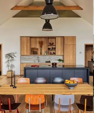 Cocina con elegantes gabinetes de madera, sillas escolares retro e iluminación industrial