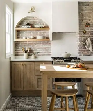 Cocina rústica moderna con nichos de ladrillo visto, estanterías de pared y armarios de madera.
