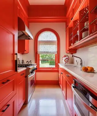 cucina arancione brillante con finestra ad arco