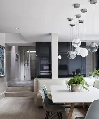 En kjøkkenbelysningside med downlights og svarte pendellys over et par hvite øyer
