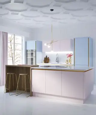 Et eksempel på moderne kjøkkenbelysningsideer som viser et kjøkken i nyanser av pastellrosa og blått med gullkanter